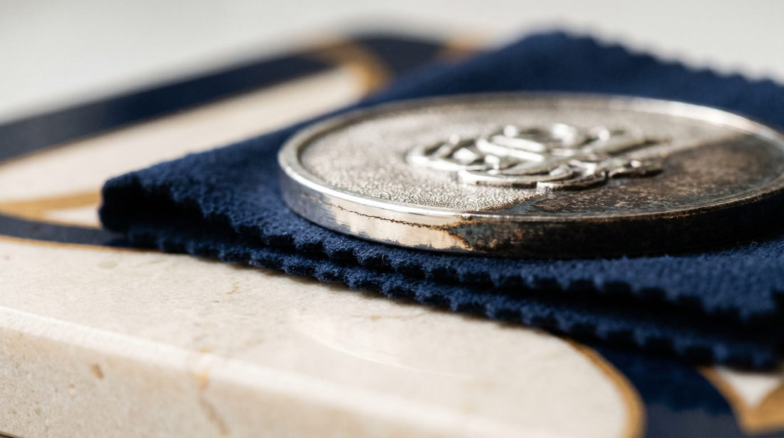 Entretenir un bijou en argent qui noircit : médaille à demi ternie sur un chiffon