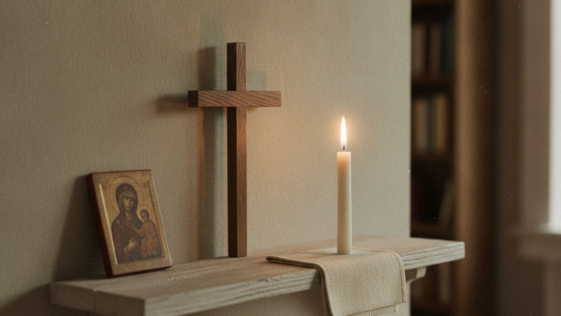 Coin prière domestique sur une étagère de bois : crucifix simple, bougie allumée, linge plié et petite icône