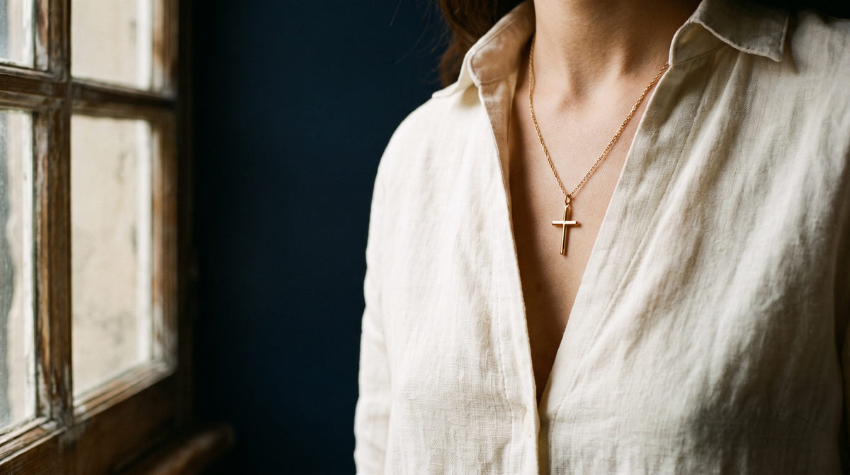 Pourquoi porter une croix autour du cou : croix dorée sur une chemise de lin ouverte