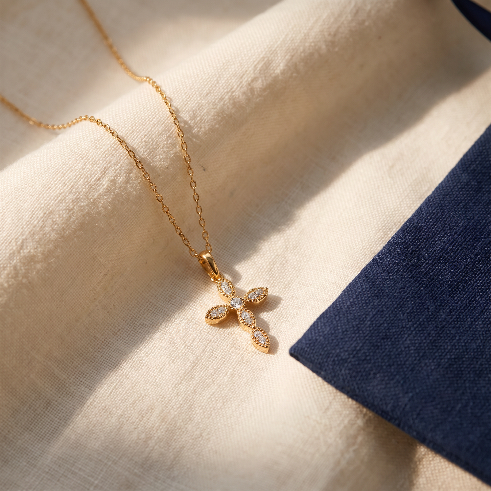 Bague croix catholique - Augustin posé sur du lin ivoire, pochon marine en accent