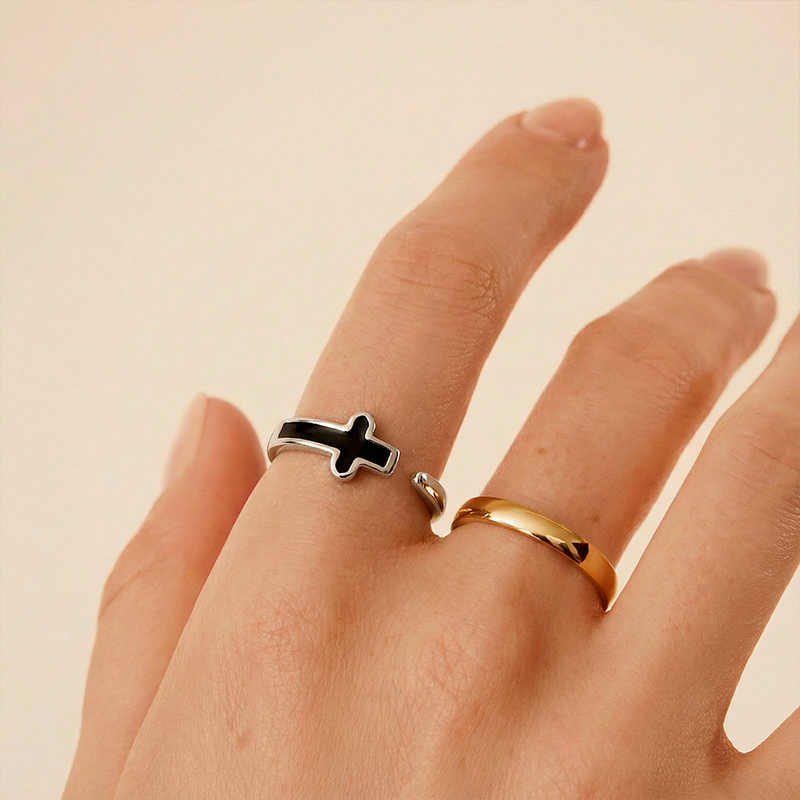 Bague croix noire, portée au doigt