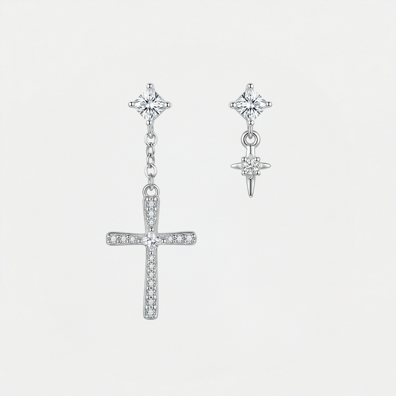 Boucles d'oreilles croix asymétriques, argentées, sur fond blanc