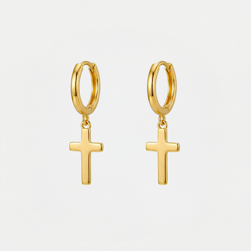 Boucles d'oreilles croix pendantes, dorées, sur fond blanc