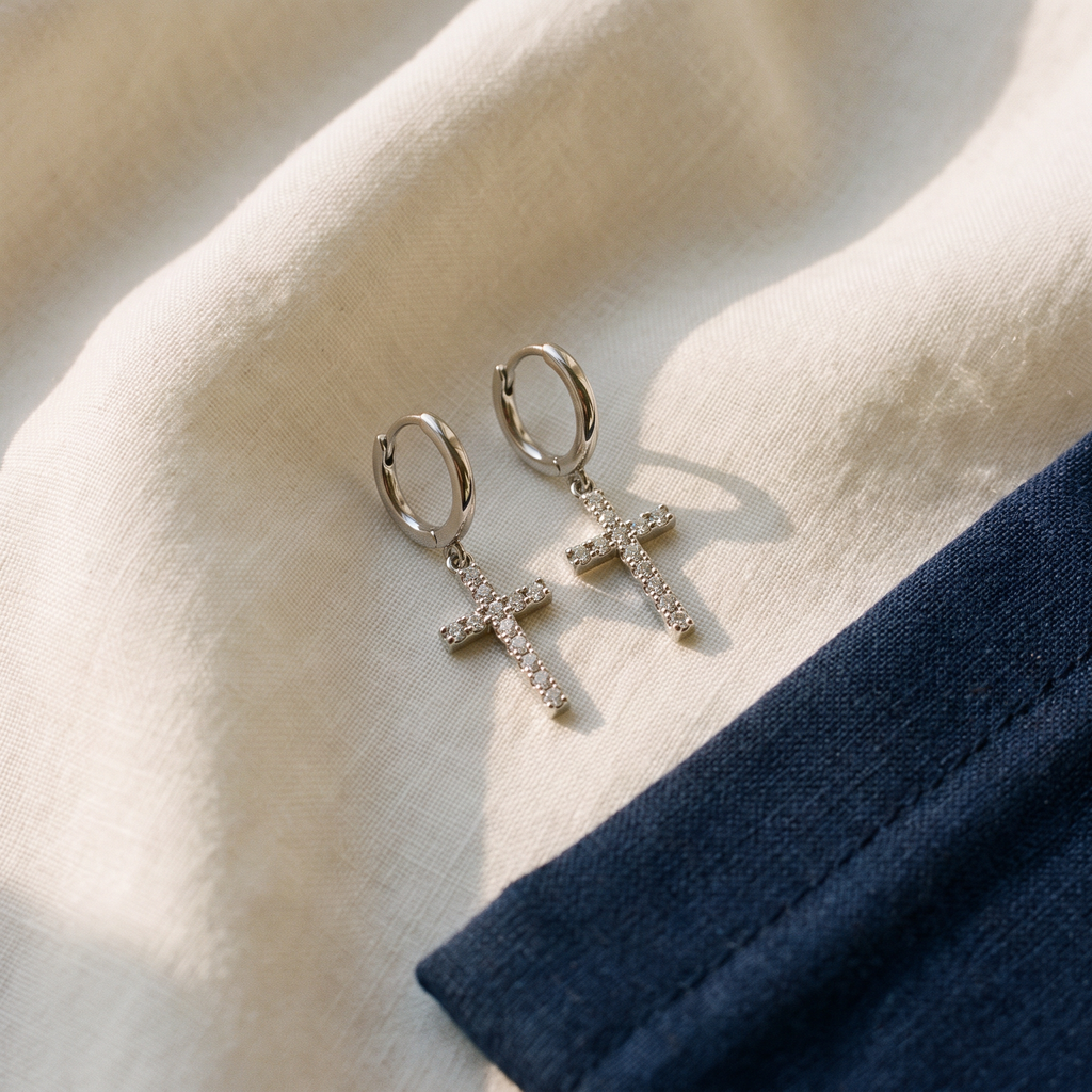 Boucles d'oreilles croix strass - Estelle posé sur du lin ivoire, pochon marine en accent