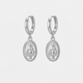 Boucles d'oreilles Vierge Marie, dorées, sur fond blanc