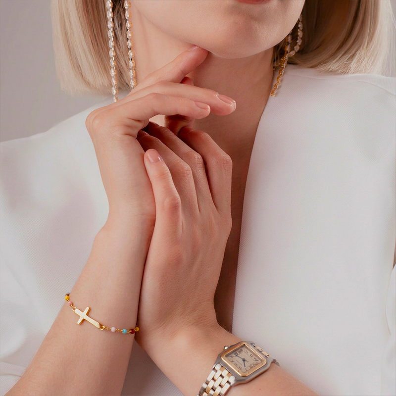 Bracelet croix fantaisie, porté au poignet