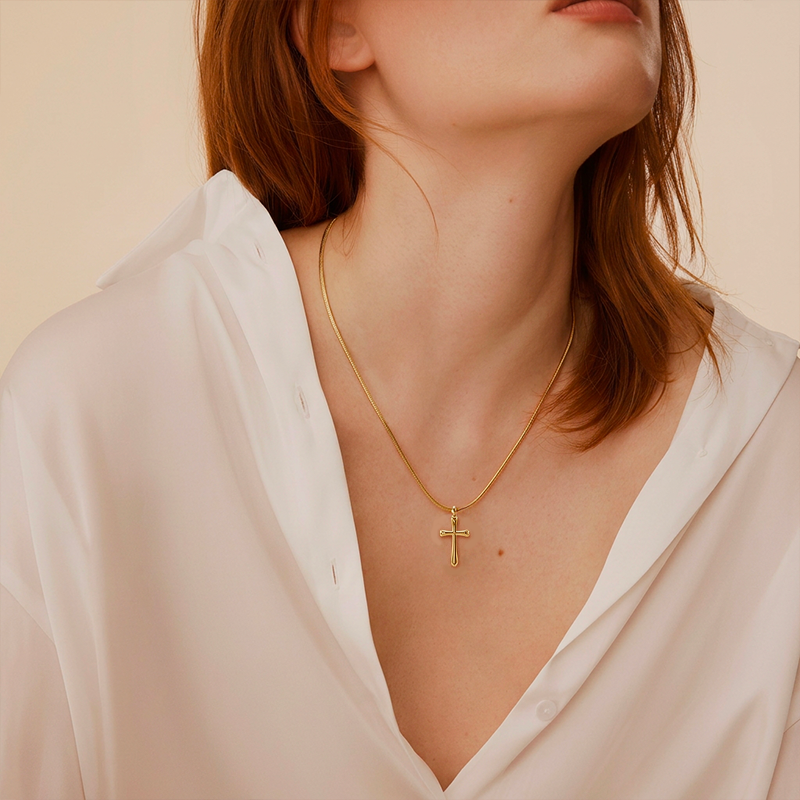Collier croix doré, porté au cou