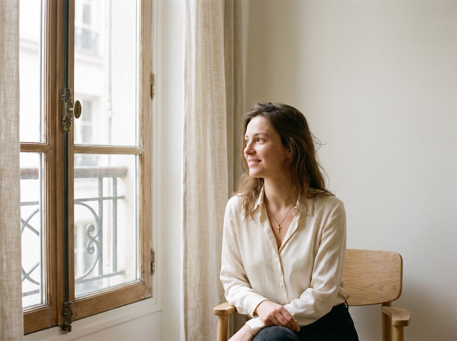 Femme portant un collier croix fin, lumière du matin